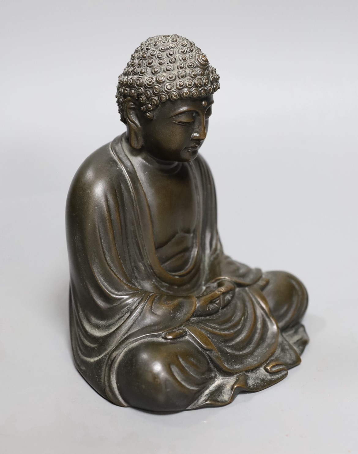 An early 20th century Japanese bronze figure of a seated Buddha, signed, 17cm